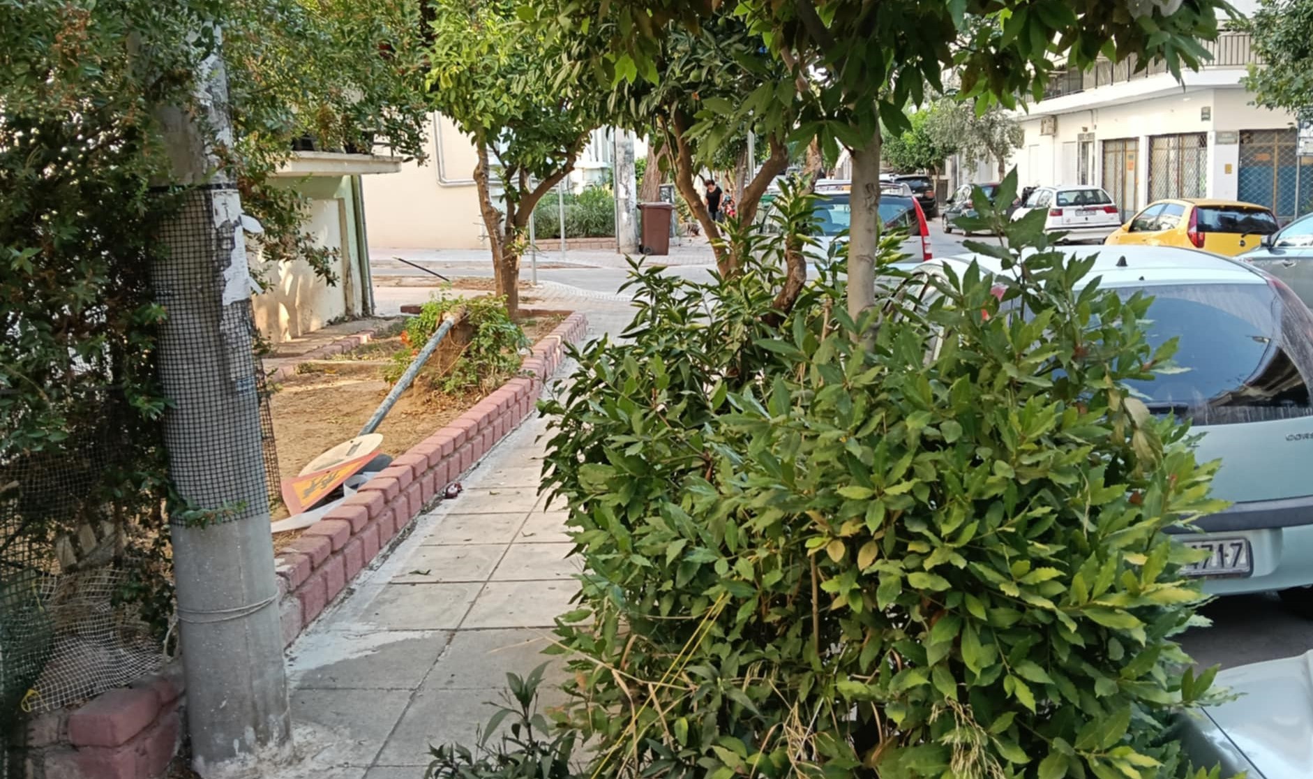 Πεταμένος σε παρτέρι στην οδό Βουτένης στύλος με πινακίδες Σχολείου και κυκλοφορίας